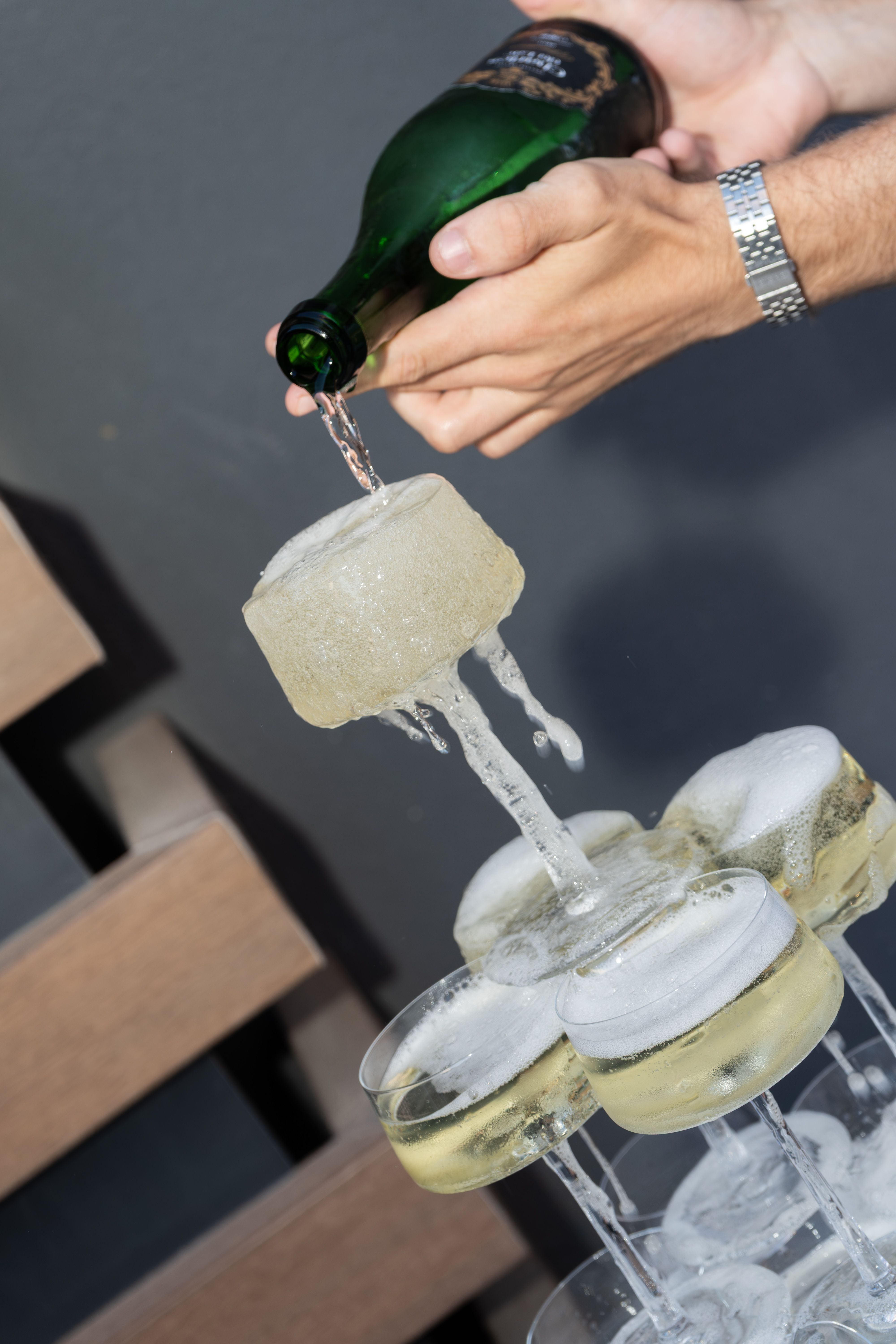 Pouring sparkling wine over a champagne glass tower