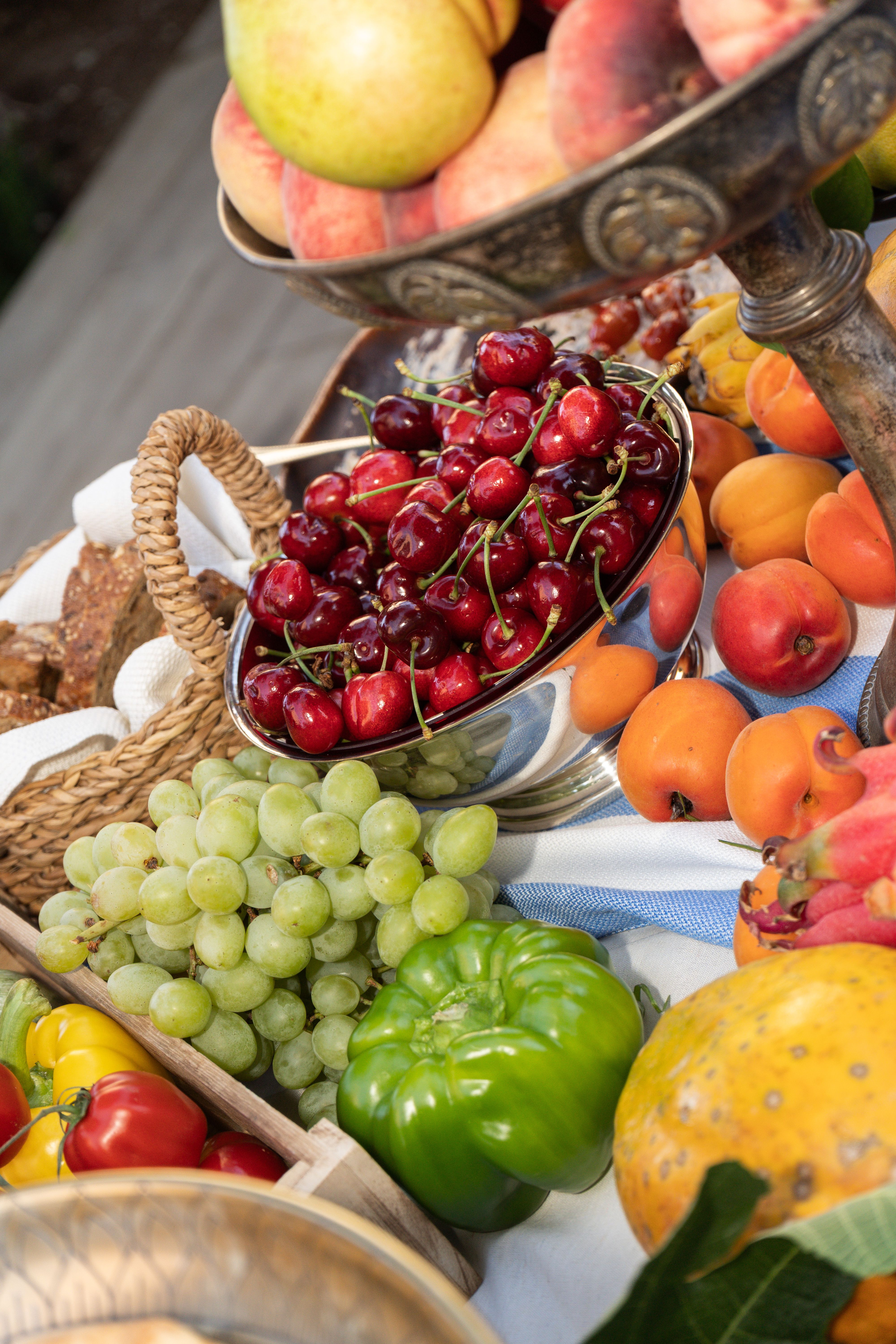 Silver bowls of fresh cherries and seasonal fruit