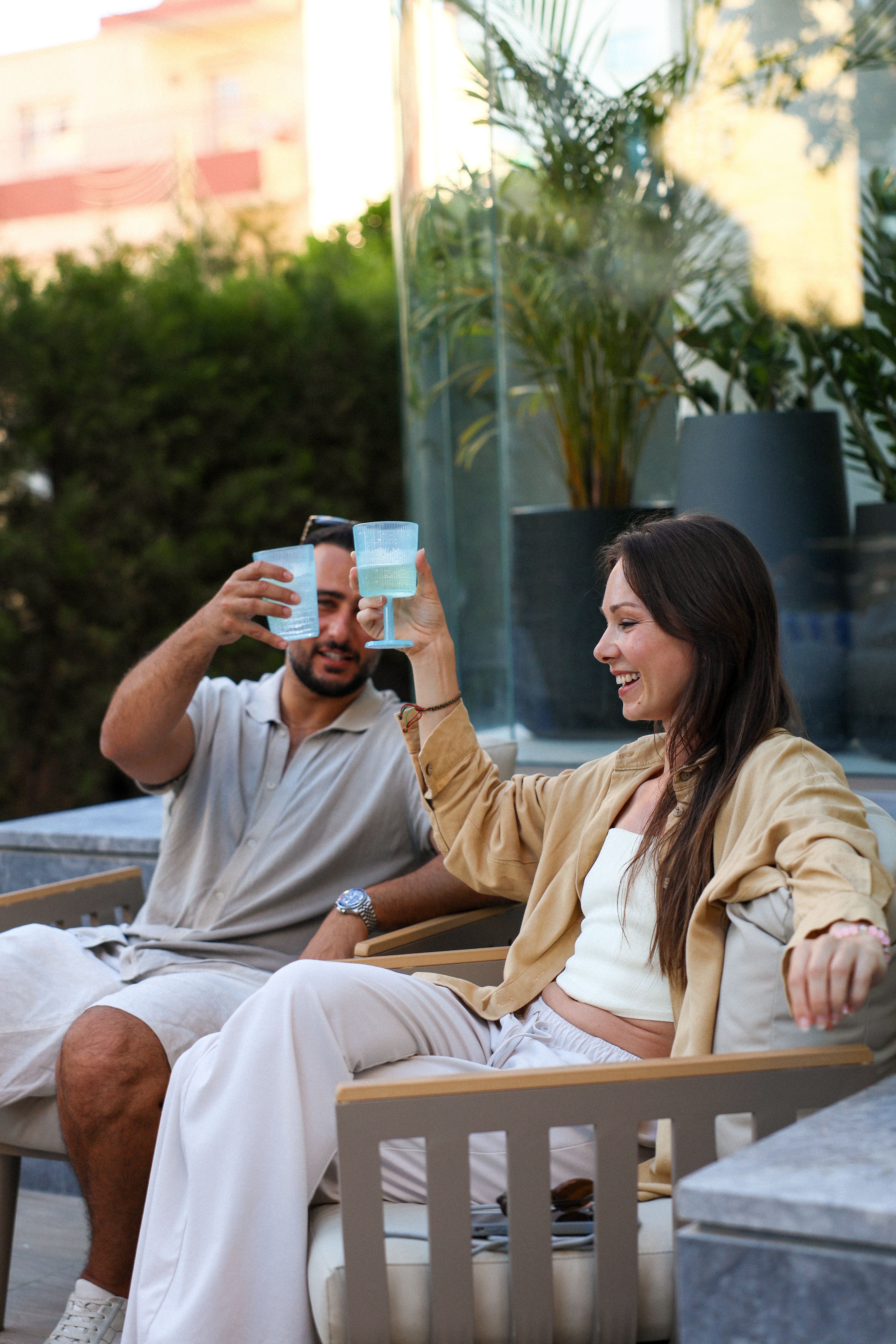 Couple toasting drinks at a poolside event