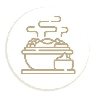 A steaming bowl of food with a side of sauce.