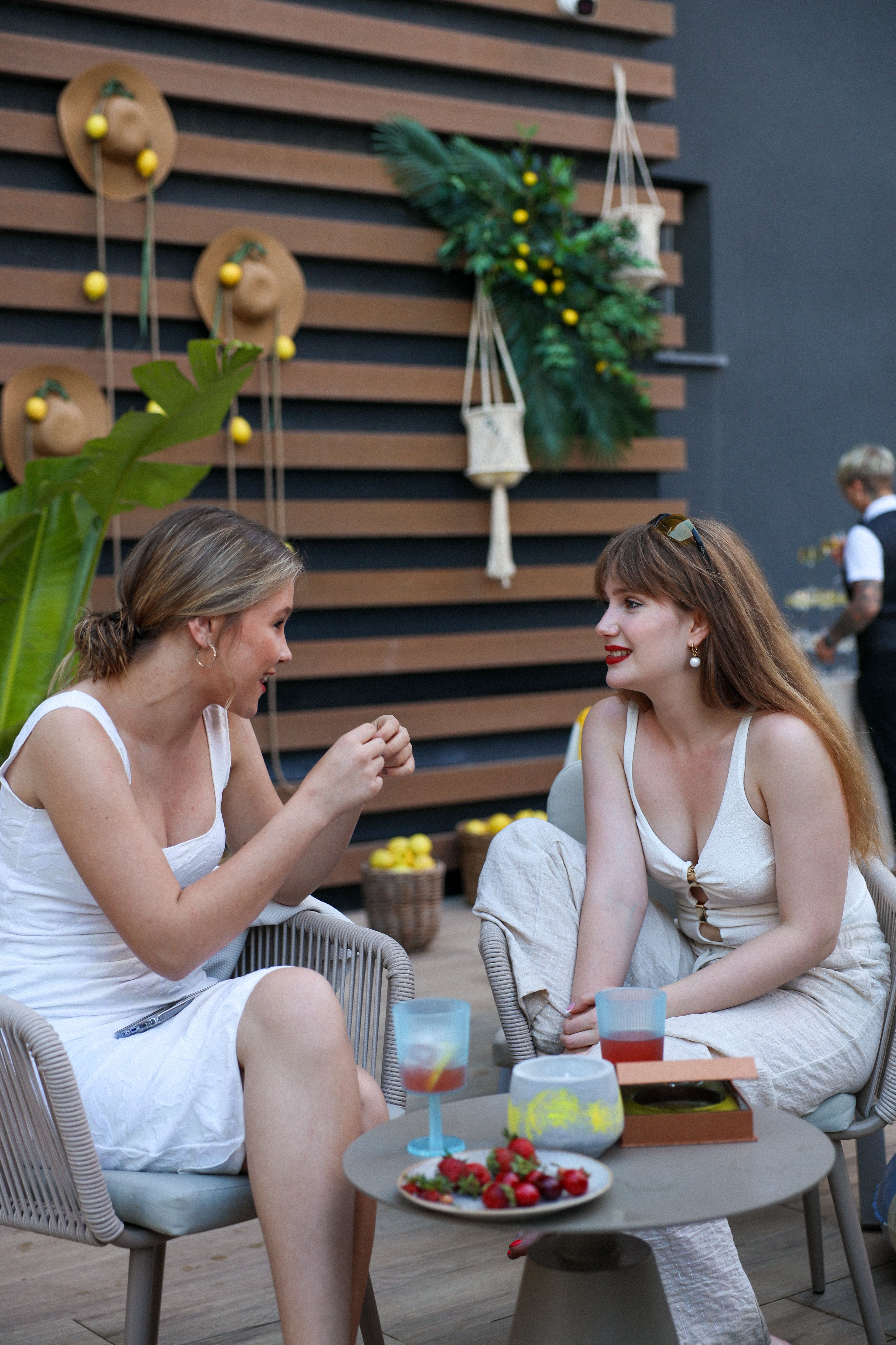 Guests chatting over drinks by the lemon wall