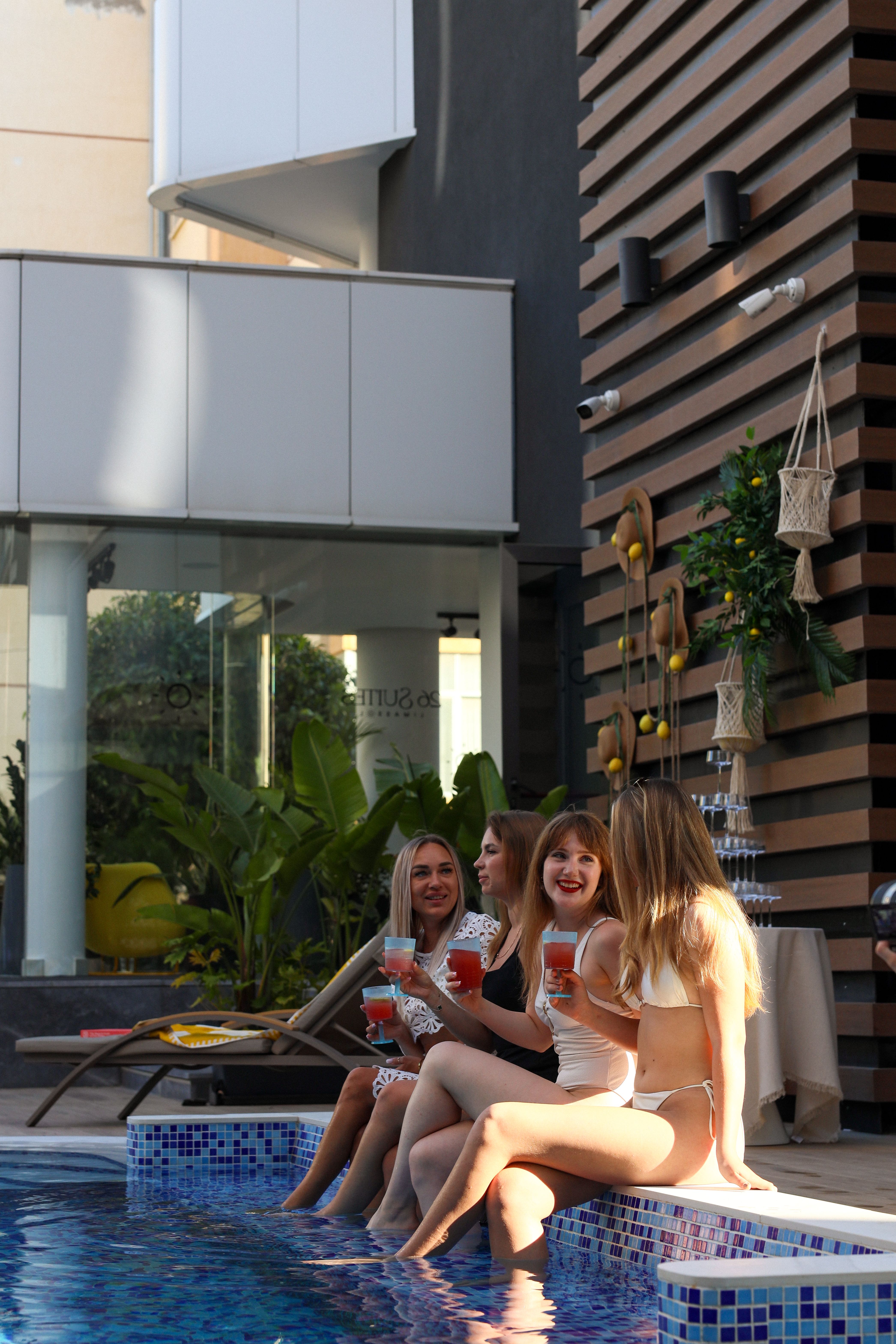 Friends enjoying cocktails by the pool at golden hour