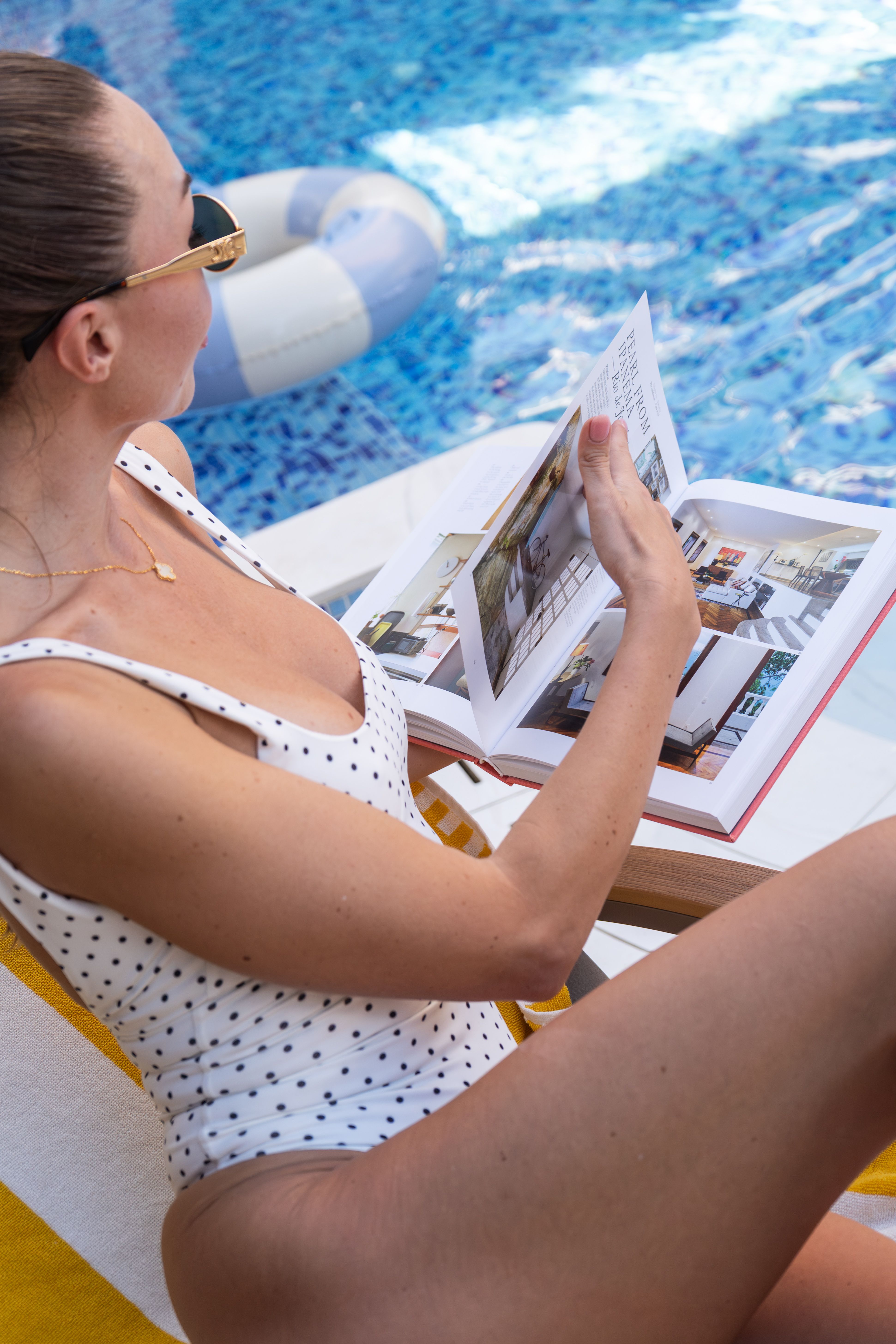 Guest reading a book on a sun lounger by the pool