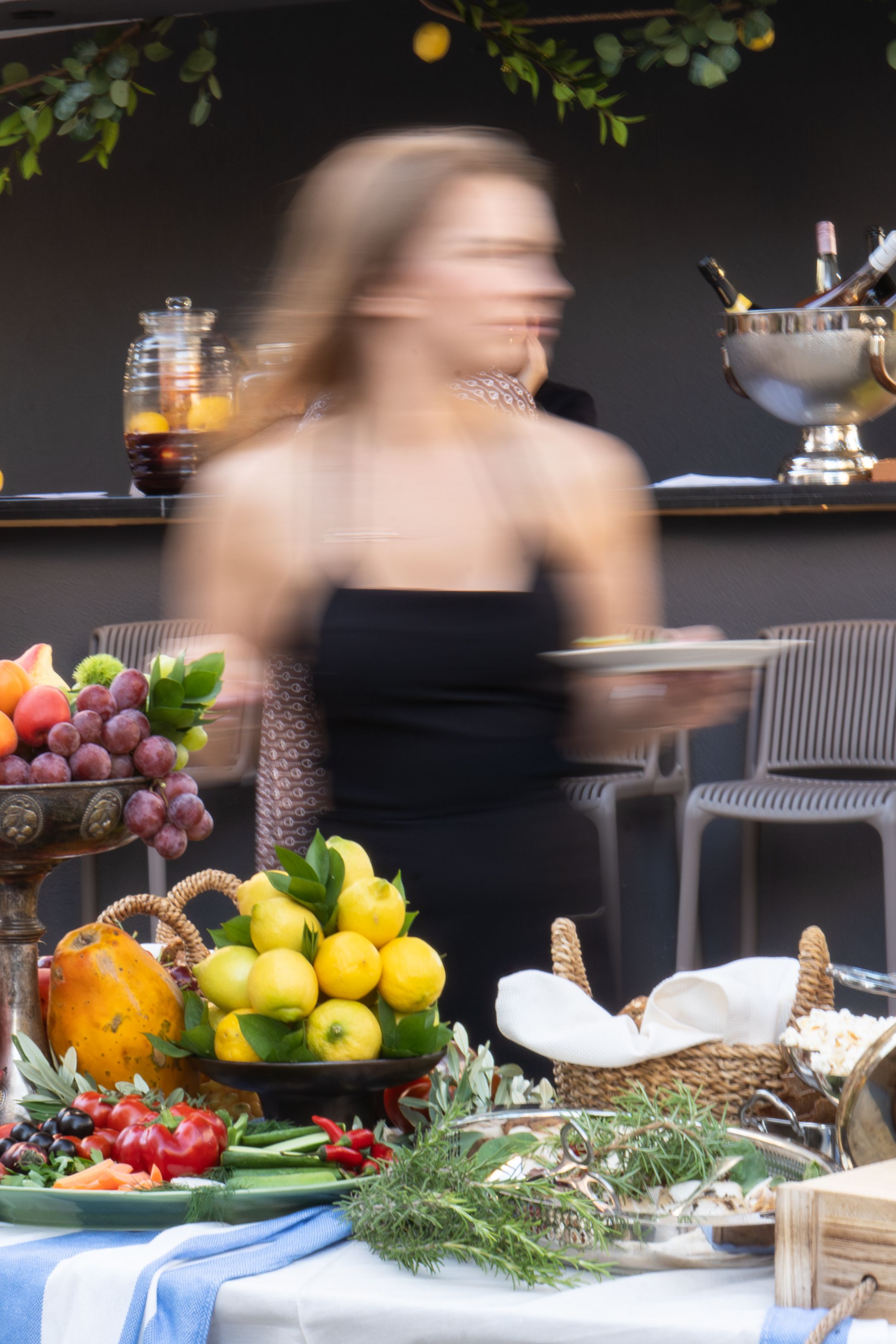 Server carrying a plate past the celebration spread